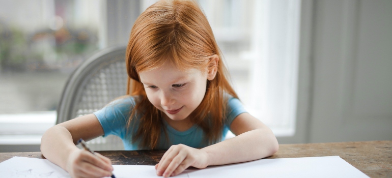 una niña escribe en un cuaderno