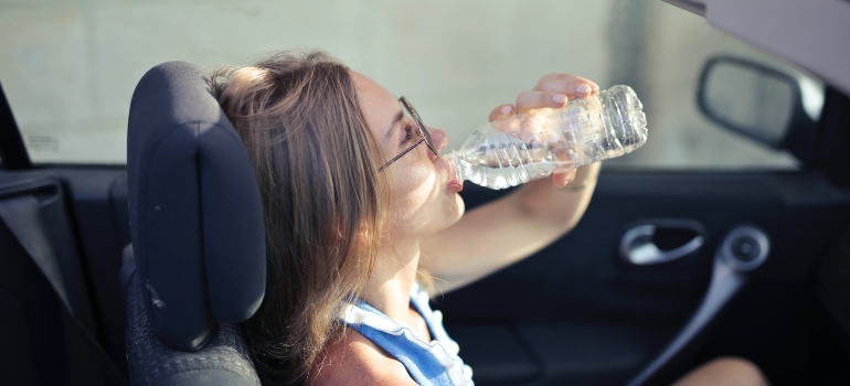 una mujer de agua potable, mientras que el verano se mueve en Texas