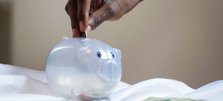 a person putting a coin in a piggy bank