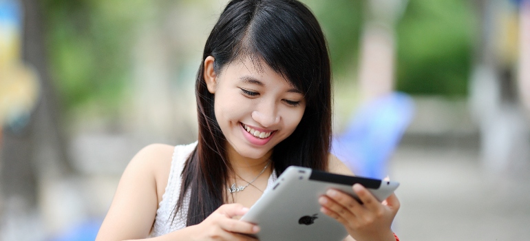 a woman looking at her tablet reading about moving to Buda with family