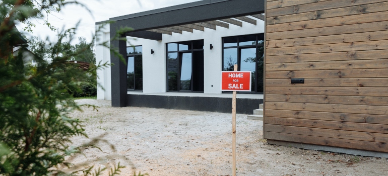 a "for sale" sign in front of a house 