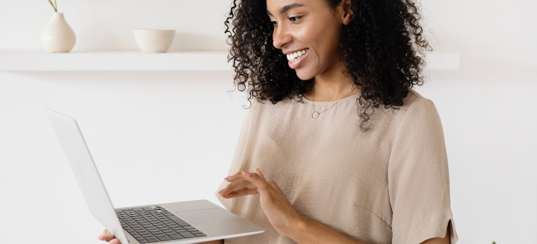 a woman looking at her laptop looking for ways to avoid moving scams when leaving Texas