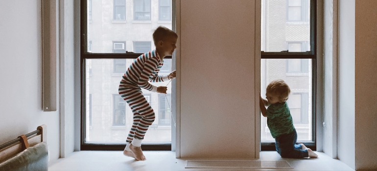 children playing near a window 