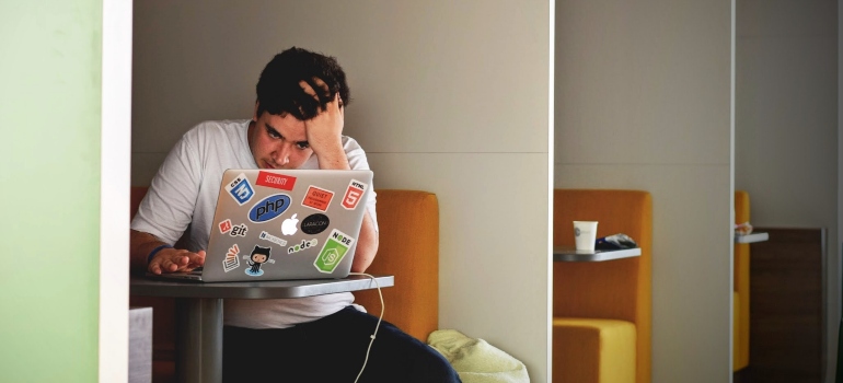 a worried man looking at his laptop 